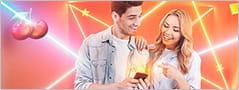 Imagen del casino online español Betsson en la que dos personas disfrutan en el móvil del paquete de bonos y otras promociones que ofrece este operador.
