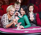 Imagen de una mesa de cartas en la que varios jugadores disfrutan del blackjack.